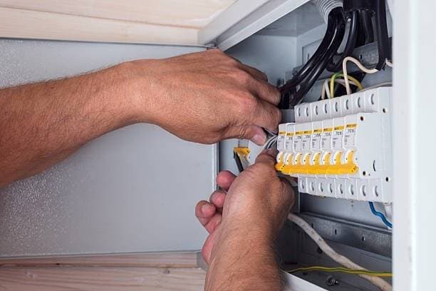 A person’s hands working with wires and circuit breakers inside an electrical panel, using a screwdriver to adjust or install components—perfect for showcasing 24 hour electrician discounts Surrey. A person’s hands working with wires and circuit breakers inside an electrical panel, using a screwdriver to adjust or install components—perfect for showcasing 24 hour electrician discounts Surrey.