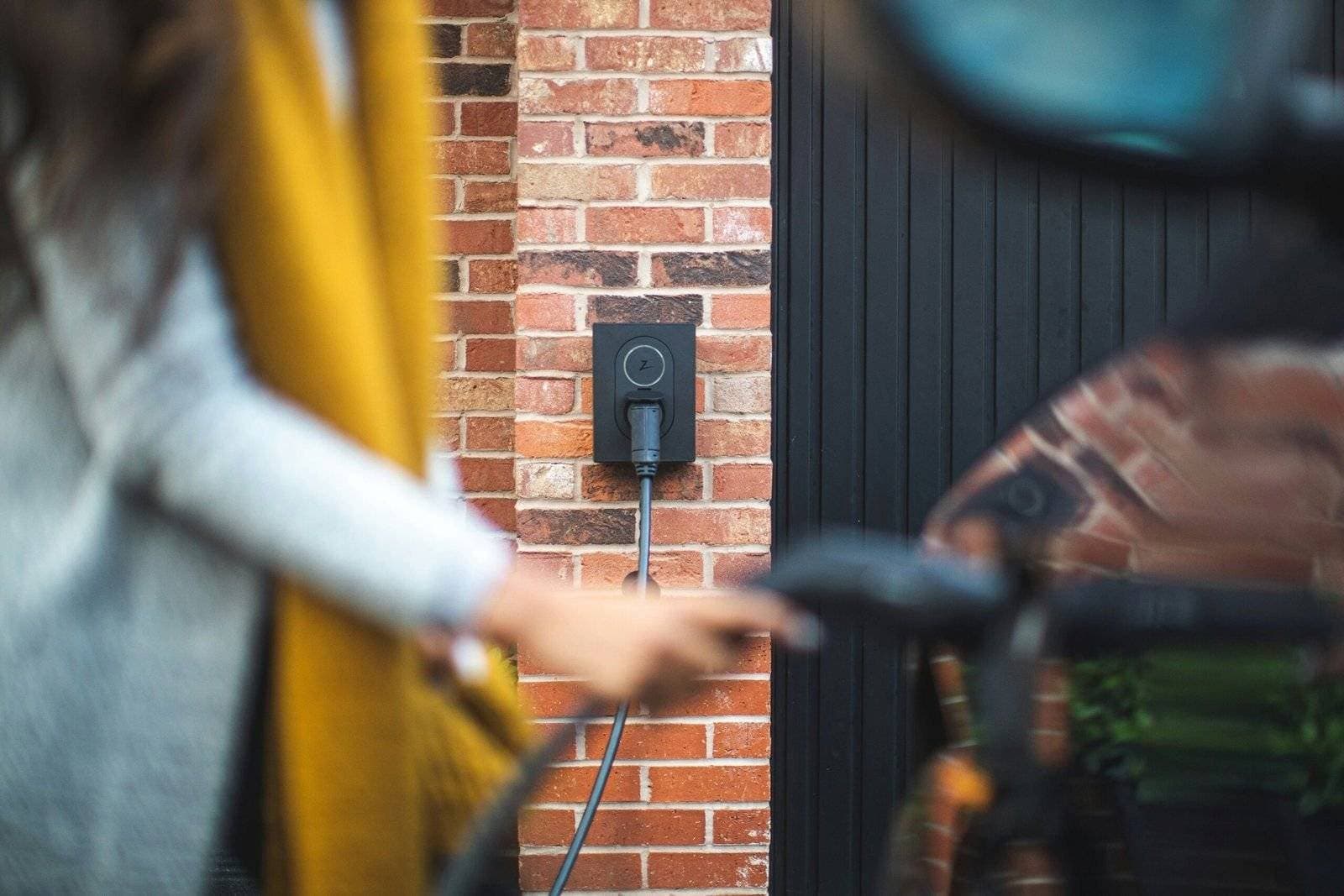ev-charger-installation-tooting Woman charging electric car at home with EV charger installed by Buildspark in Tooting, South West London.