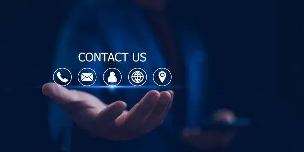 A person holds out a hand beneath floating contact icons—phone, email, chat, website, and location—with the words Contact Us above them, set against a dark blue background.