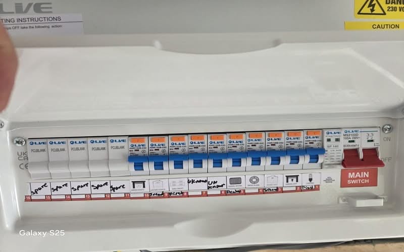 Fuse Board Upgrade Cheam SM3 | BuildSpark Electricians A newly upgraded Live Electrical metal consumer unit with labeled RCBO circuit breakers, an integrated surge protection device SPD, and a main switch, referenced as Fuse board upgrade cheam.jpeg.
